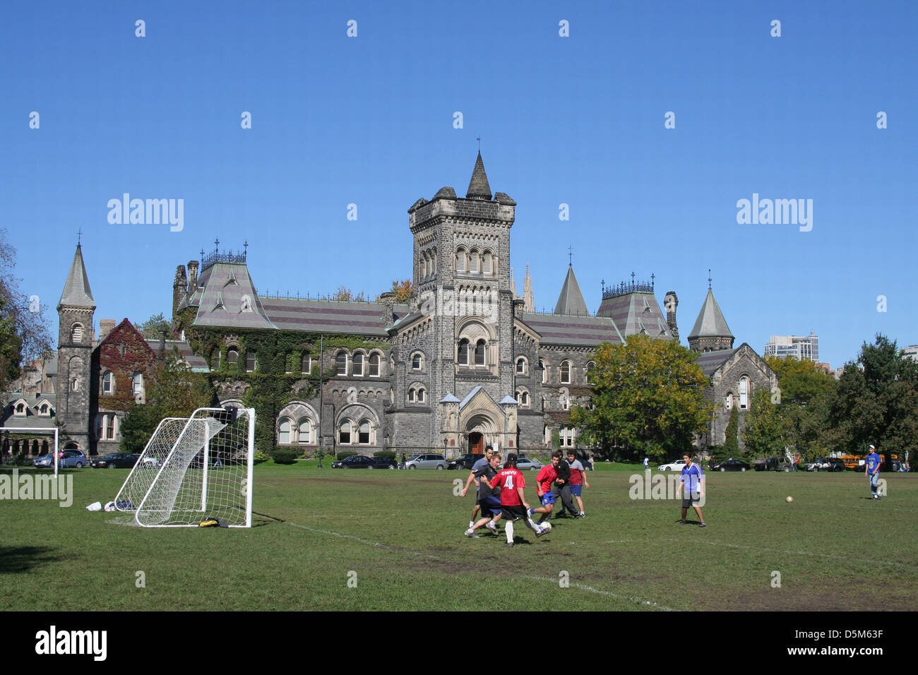 Università di Toronto davanti agli studenti del campus che giocano a calcio nella parte anteriore del Collegio Universitario Foto Stock