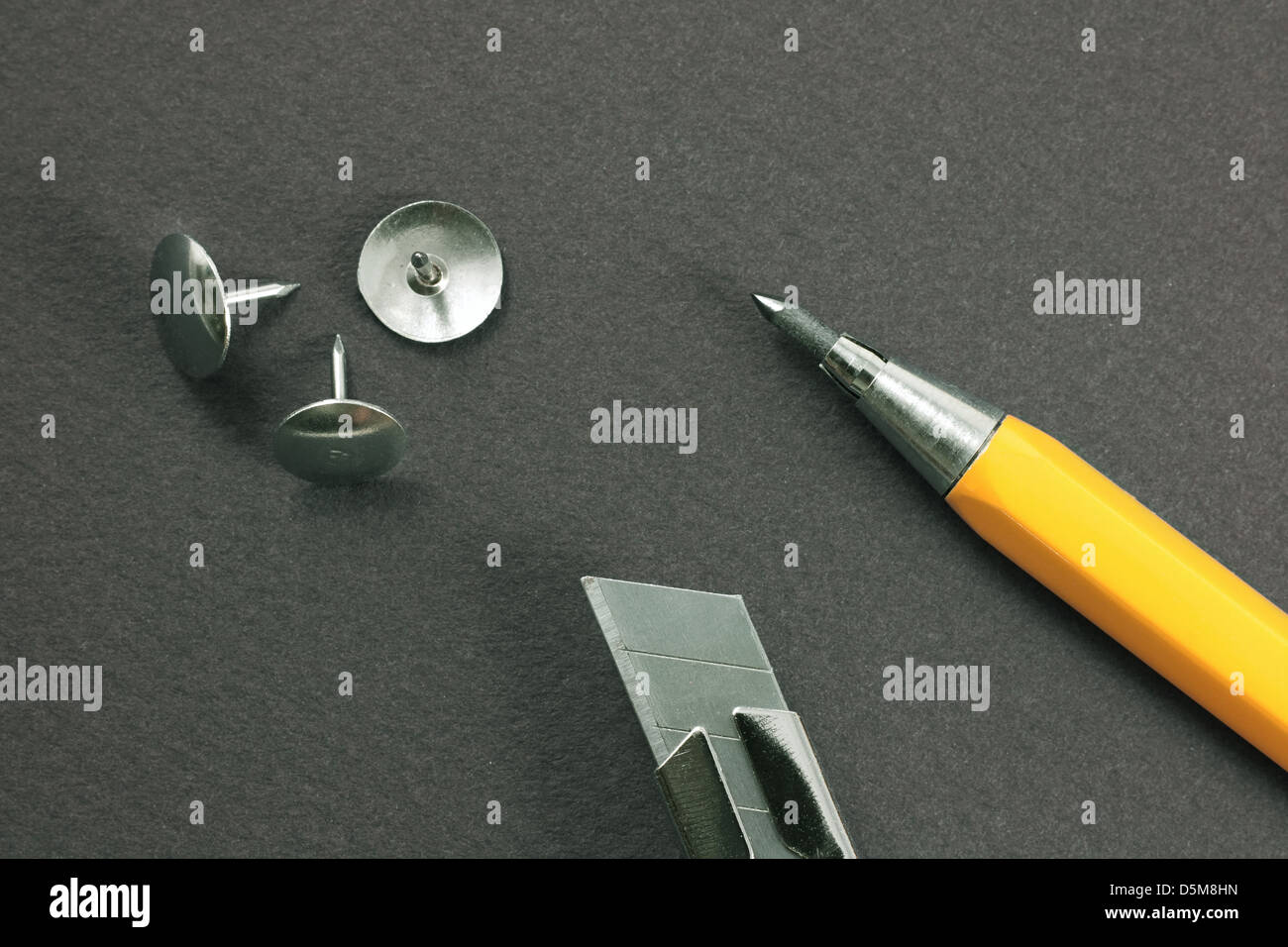 Lama retrattile coltello, Matita meccanica, disegno-pin su un cartoncino grigio Foto Stock