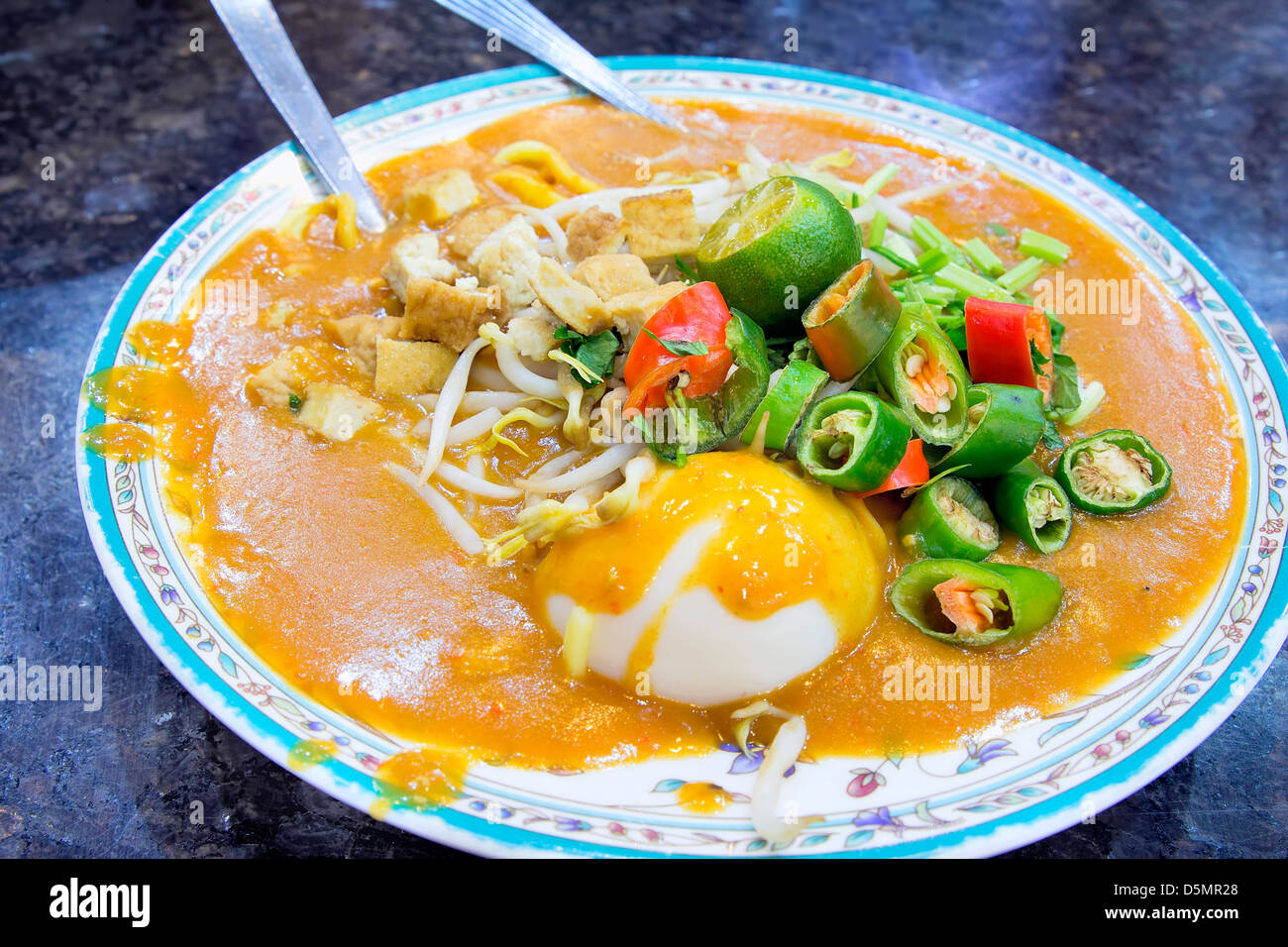 Il malese Mee Rebus Noodle piatto guarnito con taglio Peperoncino cinese Tofu Sedano e uovo sodo Foto Stock