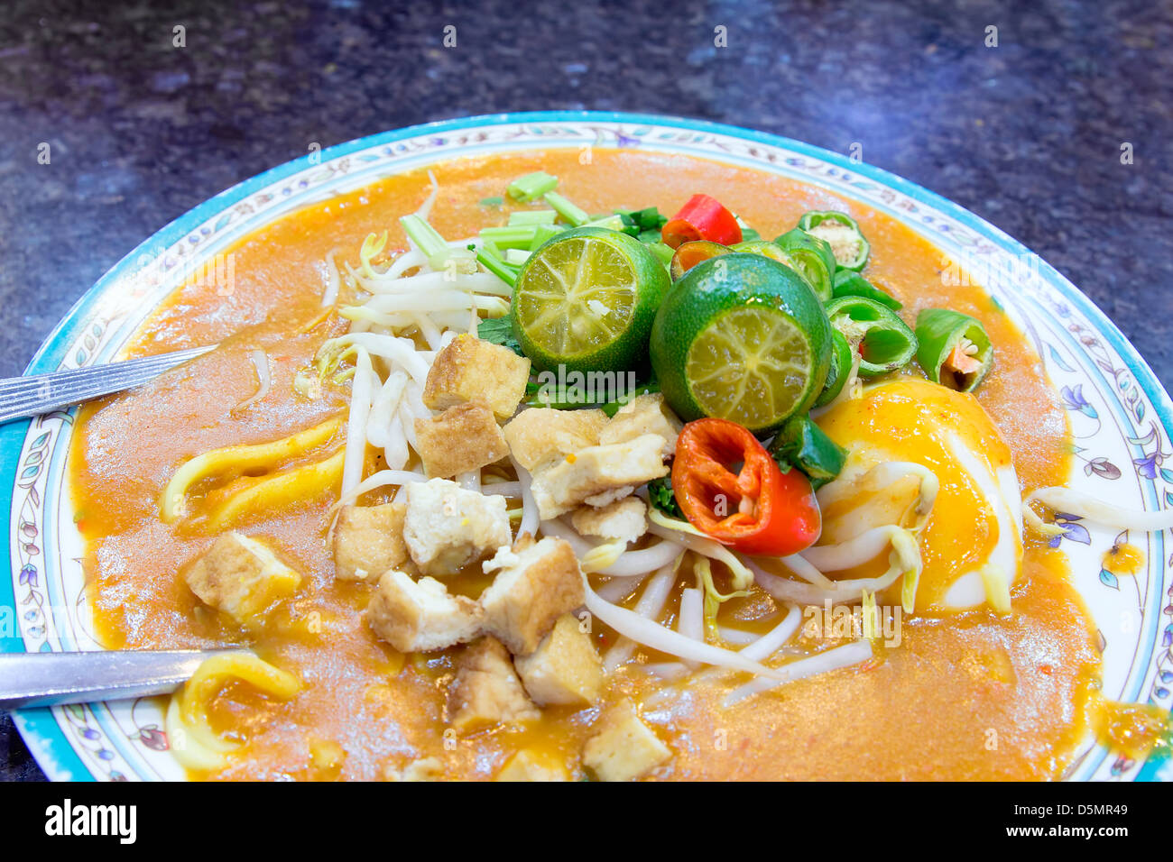 Il malese Mee Rebus Noodle piatto guarnito con taglio Peperoncino cinese Tofu Sedano e uovo sodo Closeup Foto Stock