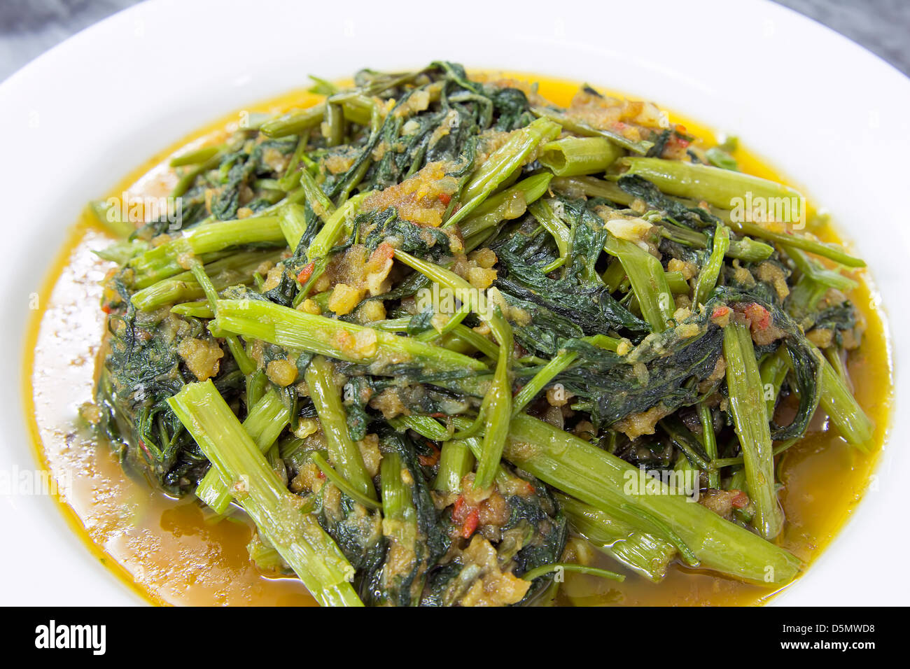 Piccante verdure Kangkong Stir Fry con gamberi secchi e Sambal pasta di peperoncino Closeup Macro Foto Stock