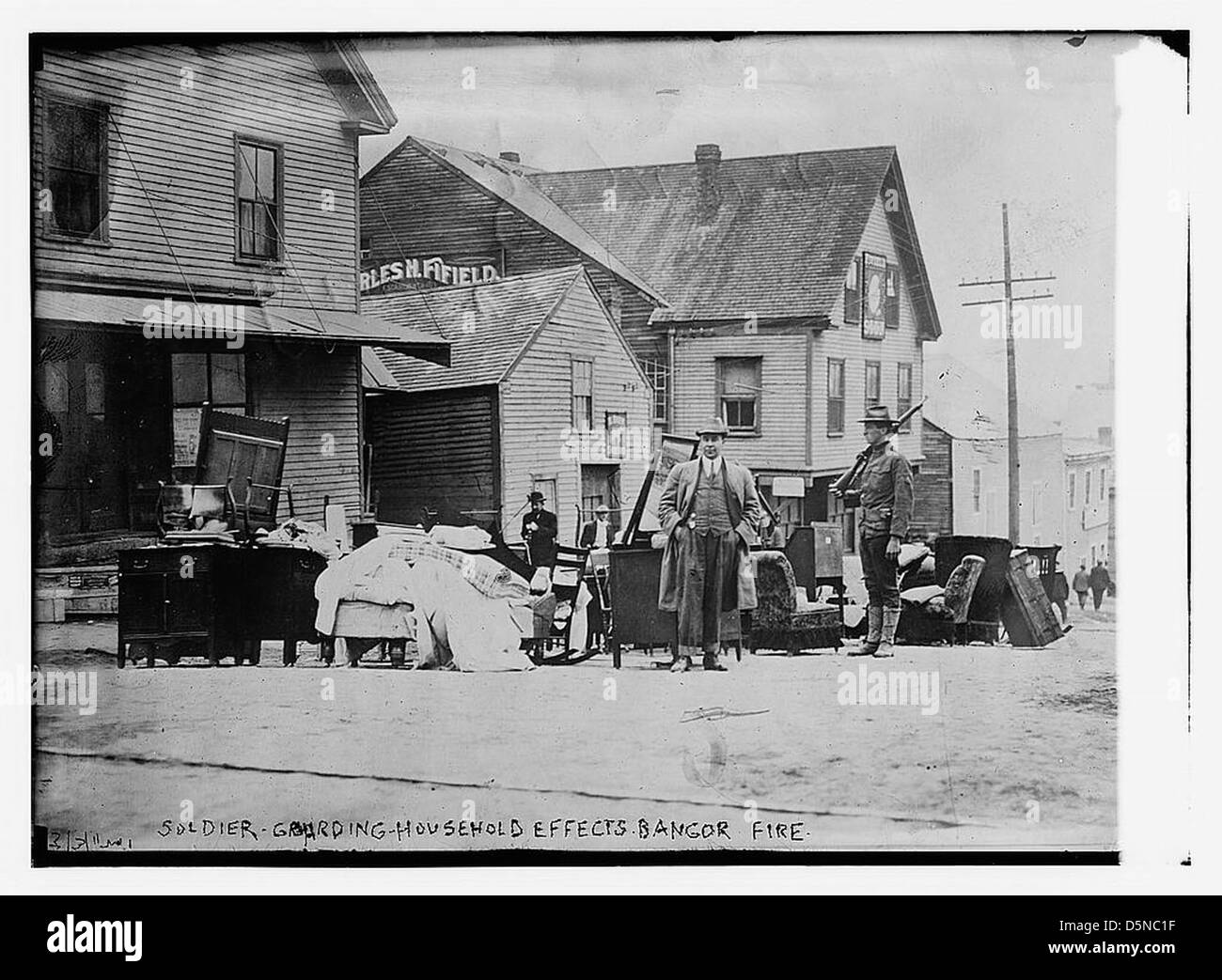 Questa foto del grande incendio del 1911 a Bangor, Maine, mostra un soldato che custodisce oggetti per la casa. L'incendio ha devastato gran parte della città, e questa immagine cattura un momento delle conseguenze. Foto Stock