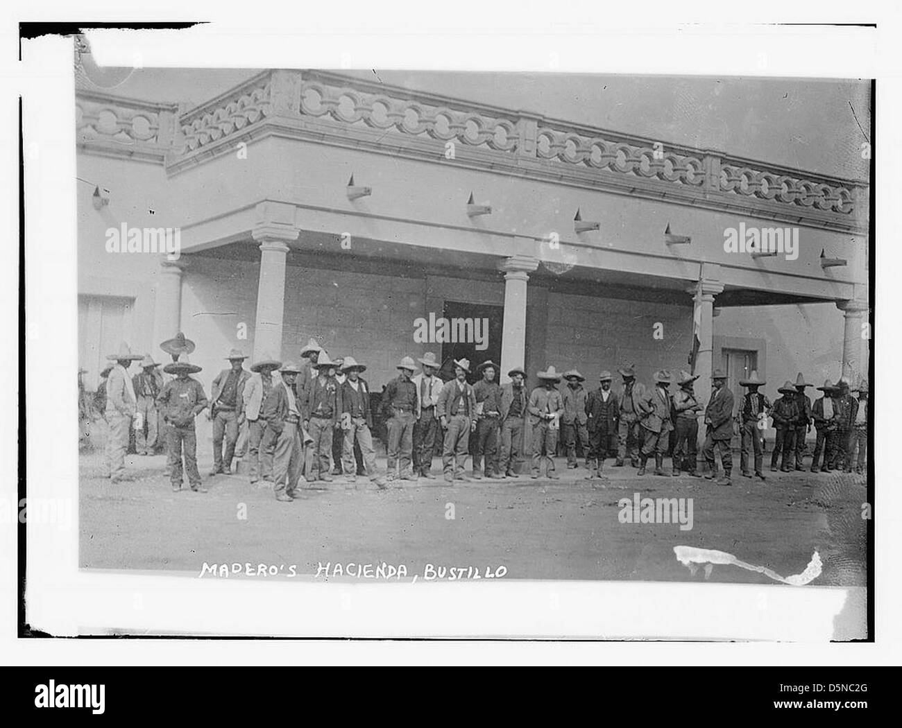 Questa immagine mostra Francisco I. Madero all'Hacienda de Bustillos durante la rivoluzione messicana, intorno al 1911. La foto mostra una folla, una vista sul tetto e elementi tradizionali come i sombreri, riflettendo al contempo l'atmosfera politica e sociale dell'epoca. Foto Stock