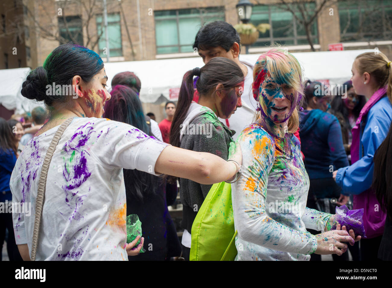 Polvere colorata viene applicata per i volti dei partecipanti come si celebra la vacanza indiano di Holi Foto Stock