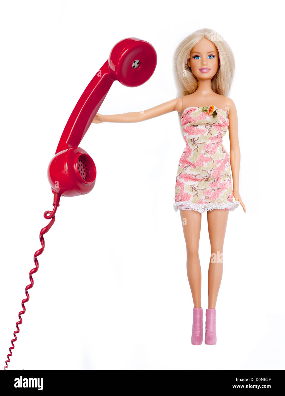 Bambola Barbie, tenendo in mano un telefono rosso ricevitore. Isolato su bianco. Foto Stock