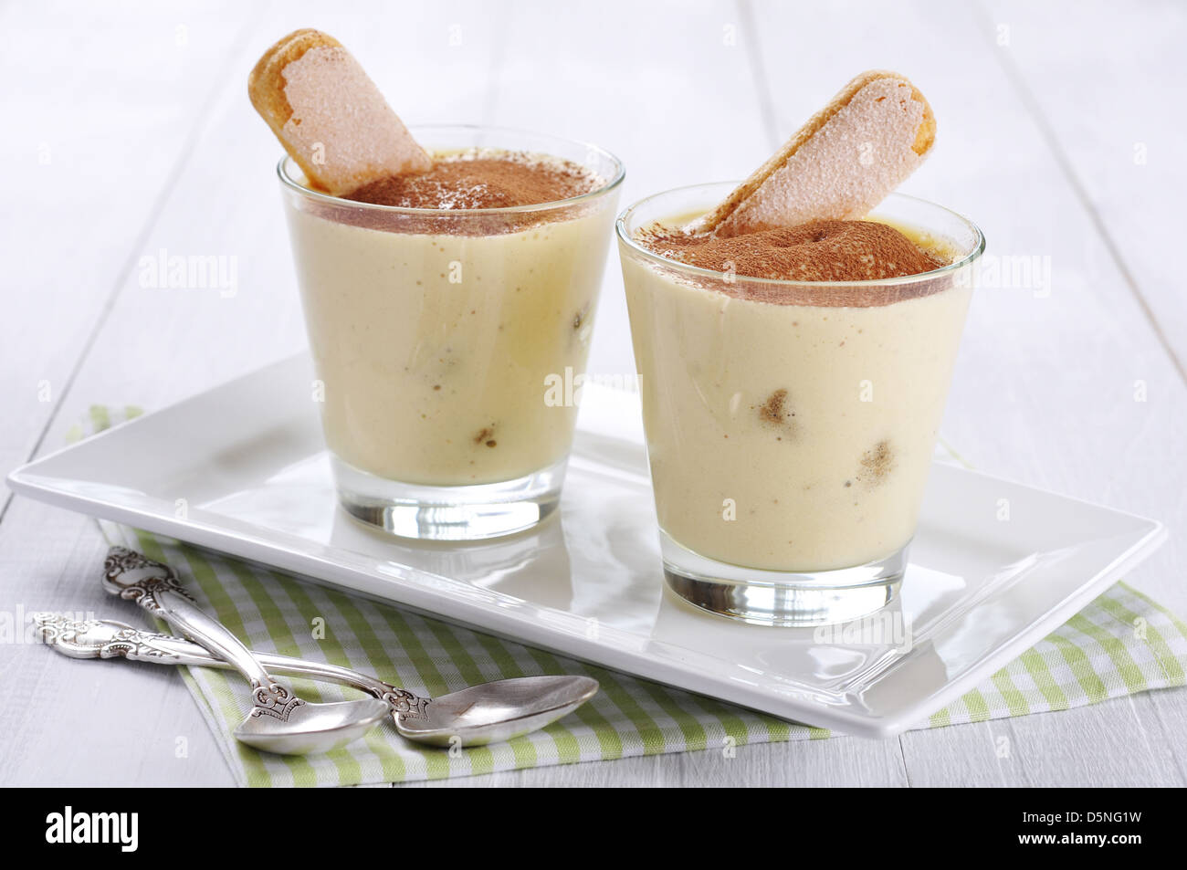 Tradizionale dolce italiano tiramisù in un bicchiere su sfondo di legno Foto Stock