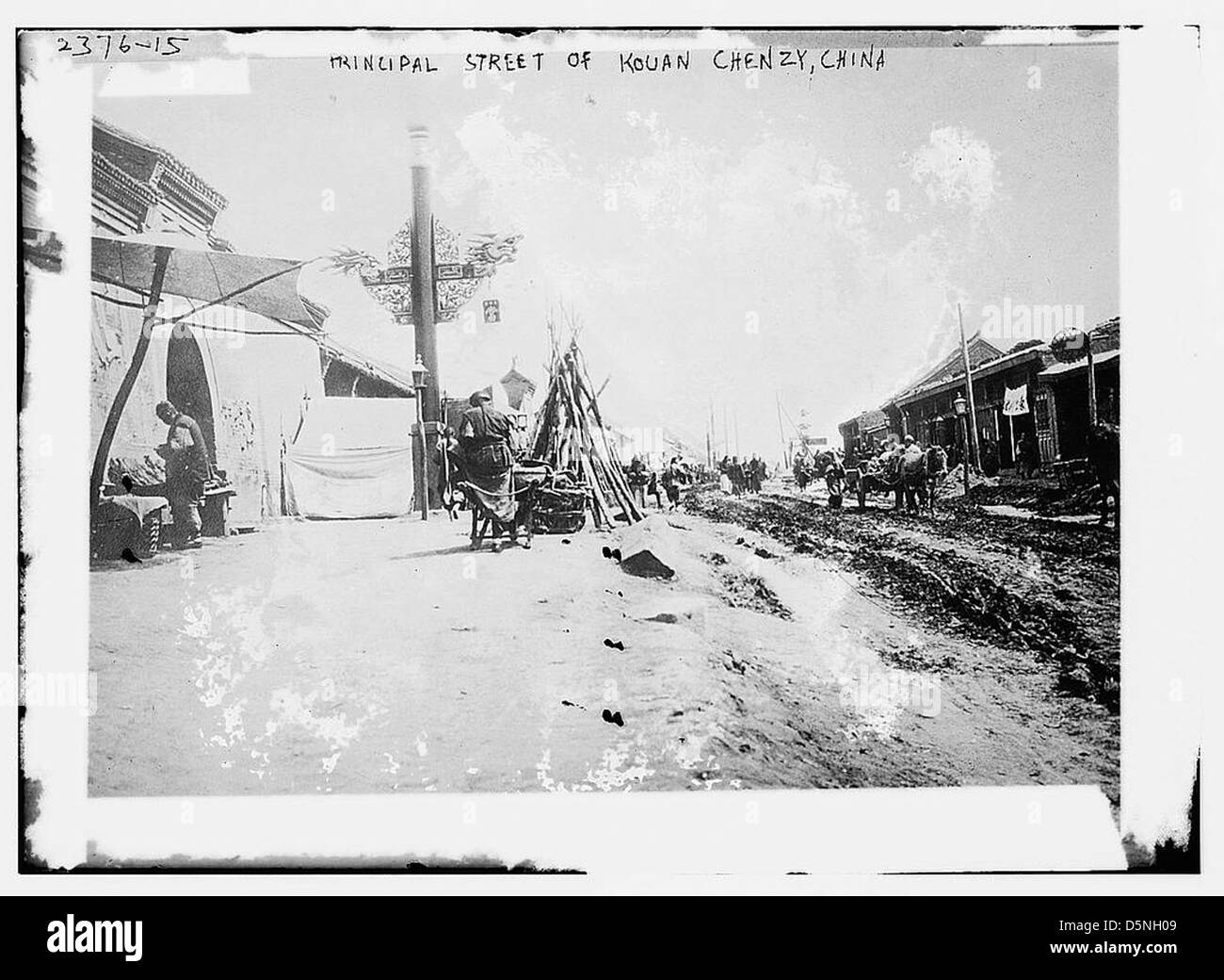 Questa fotografia mostra la strada principale di Kouan Chenzy, in Cina, negli anni '1910 La strada sterrata riflette la natura rurale e non sviluppata della regione durante questo periodo. Foto Stock