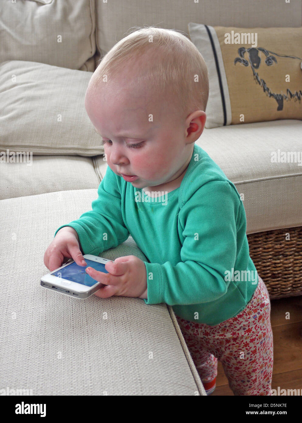 Il toddler imitando gli sms con un iPhone Foto Stock