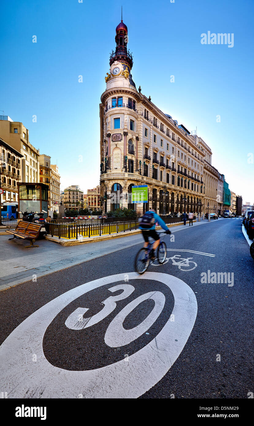 Ciclista passando per il "Banco Español de Crédito' edificio in calle Alcalá. Madrid. Spagna Foto Stock