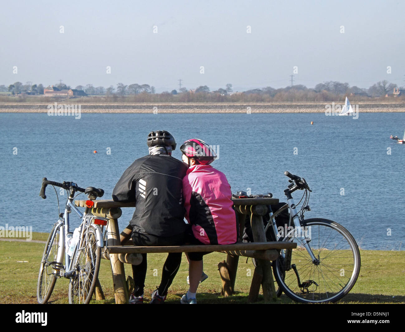 Due ciclisti (giovane) avente un periodo di riposo in riva al lago Foto Stock