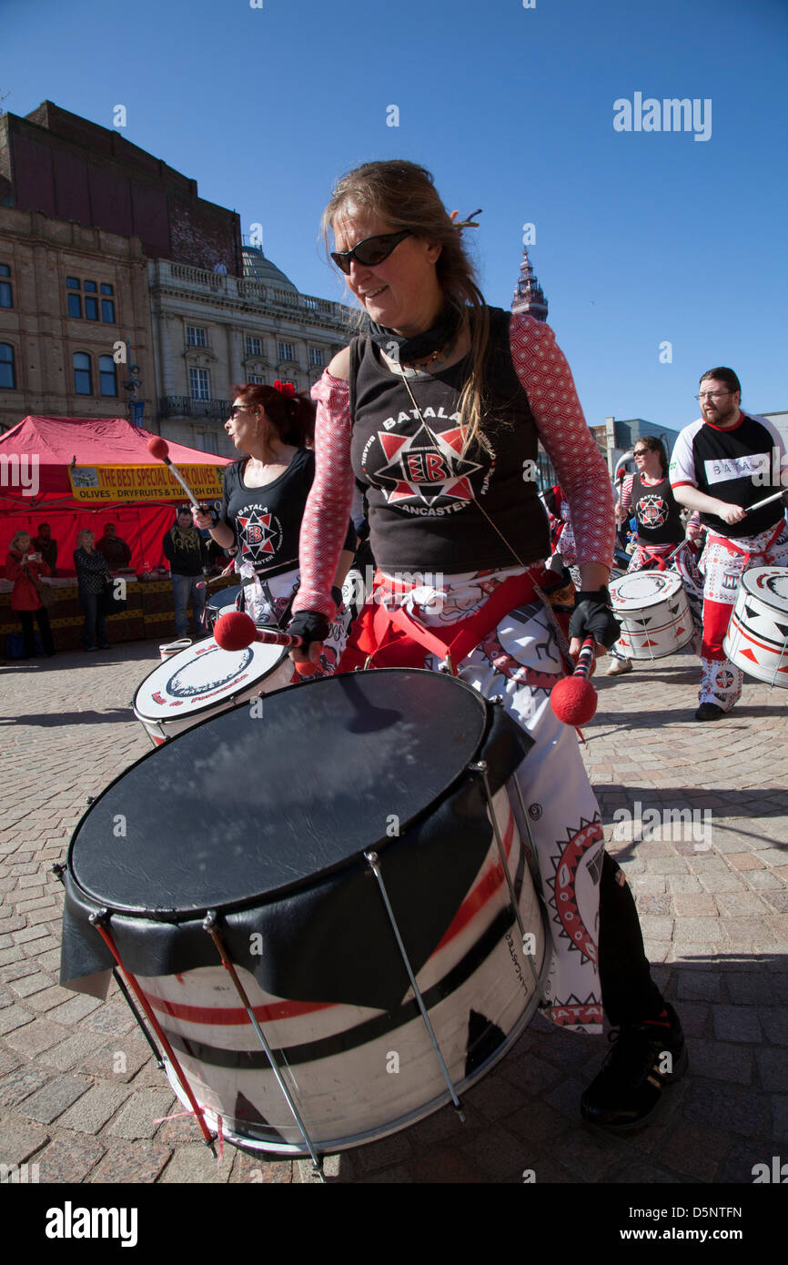 Blackpool, Lancashire, Regno Unito sabato 6 aprile 2013. Batala batterista, banda, grande tamburo, donna batterista, musica, percussioni, samba, musicista, beat, prestazioni, carnevale, gruppo, festival di Latina, celebrazione, folk, Street, Città, danza, divertente, nazionale, persone, eseguire in St Johns Square, punto di riferimento di un evento organizzato da Blackpool offerta una delle sue principali attrazioni musicali durante la stagione turistica. Foto Stock