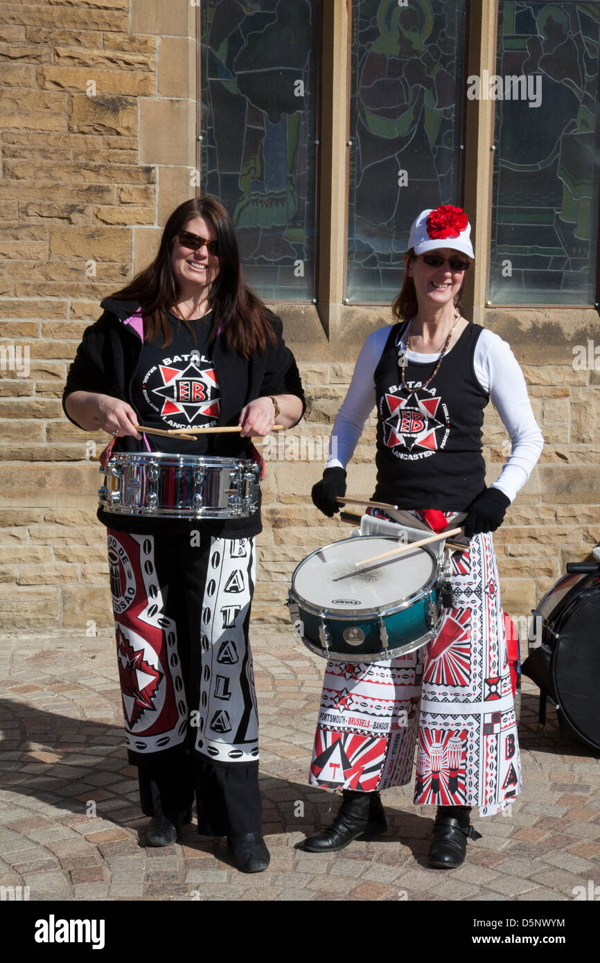 Blackpool, Lancashire, Regno Unito sabato 6 aprile 2013. Batala batterista, banda, grande tamburo, donna batterista, musica, percussioni, samba, musicista, beat, prestazioni, carnevale, gruppo, festival di Latina, celebrazione, folk, Street, Città, danza, divertente, nazionale, persone, eseguire in St Johns Square, punto di riferimento di un evento organizzato da Blackpool offerta una delle sue principali attrazioni musicali durante la stagione turistica. Foto Stock