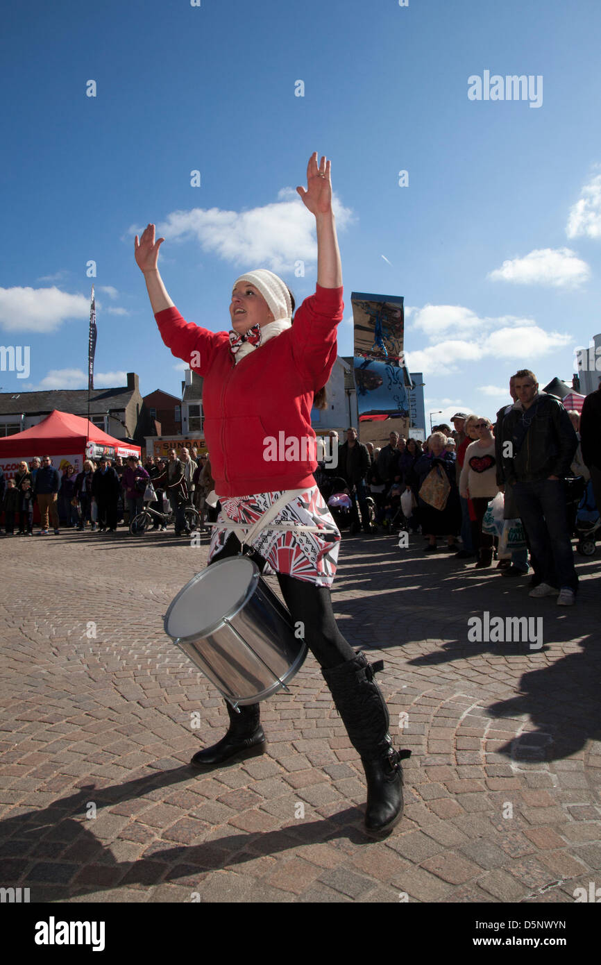 Blackpool, Lancashire, Regno Unito sabato 6 aprile 2013. Batala batterista, banda, grande tamburo, donna batterista, musica, percussioni, samba, musicista, beat, prestazioni, carnevale, gruppo, festival di Latina, celebrazione, folk, Street, Città, danza, divertente, nazionale, persone, eseguire in St Johns Square, punto di riferimento di un evento organizzato da Blackpool offerta una delle sue principali attrazioni musicali durante la stagione turistica. Foto Stock