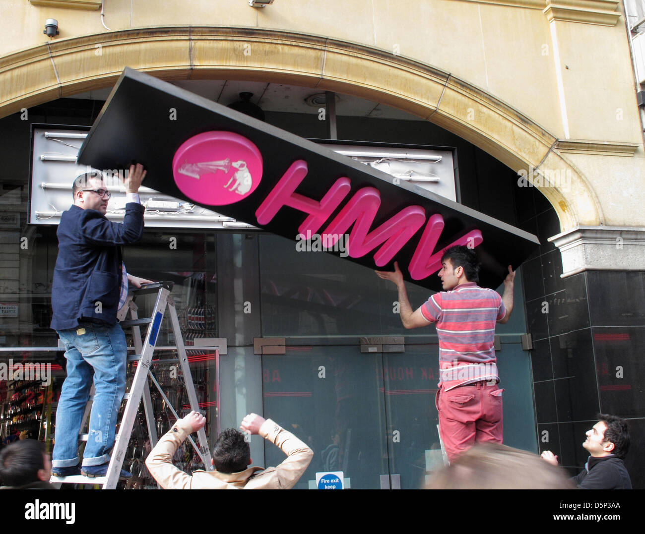 Operai rimuovere il segno al di fuori del negozio HMV in Coventry Street, Piccadilly Circus, Londra W1. Crollo di un impero retail, sembra di essere recuperata dal gruppo canadese Sunrise Records Foto Stock