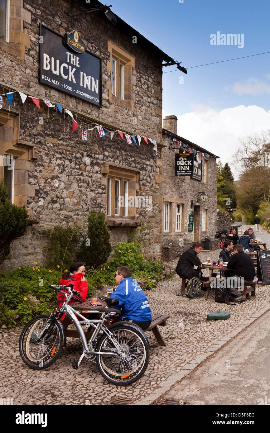 Regno Unito, Inghilterra, Yorkshire, Malham, ciclisti sat godendo bevande fuori Buck Inn pub Foto Stock