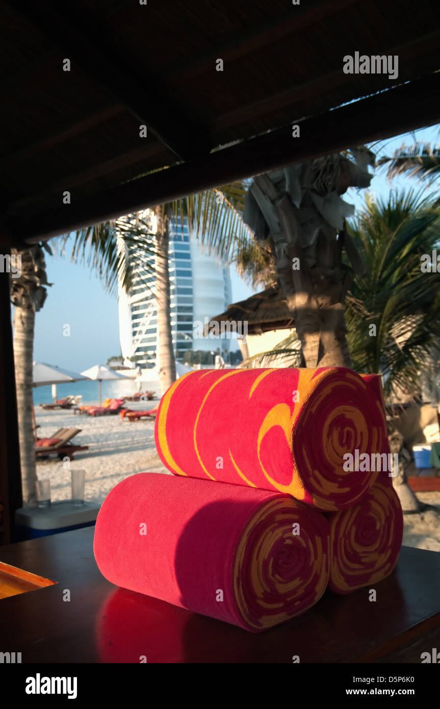 Elegante spiaggia rossa asciugamano arrotolato nel beacjof dubai.sullo sfondo la struttura delle sette stelle Burj Al Arab Foto Stock