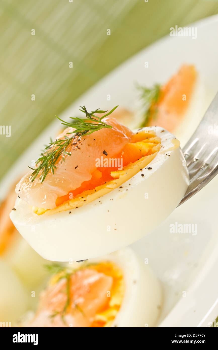 Uova sode con salmone sale cosparsi di pepe nero Foto Stock