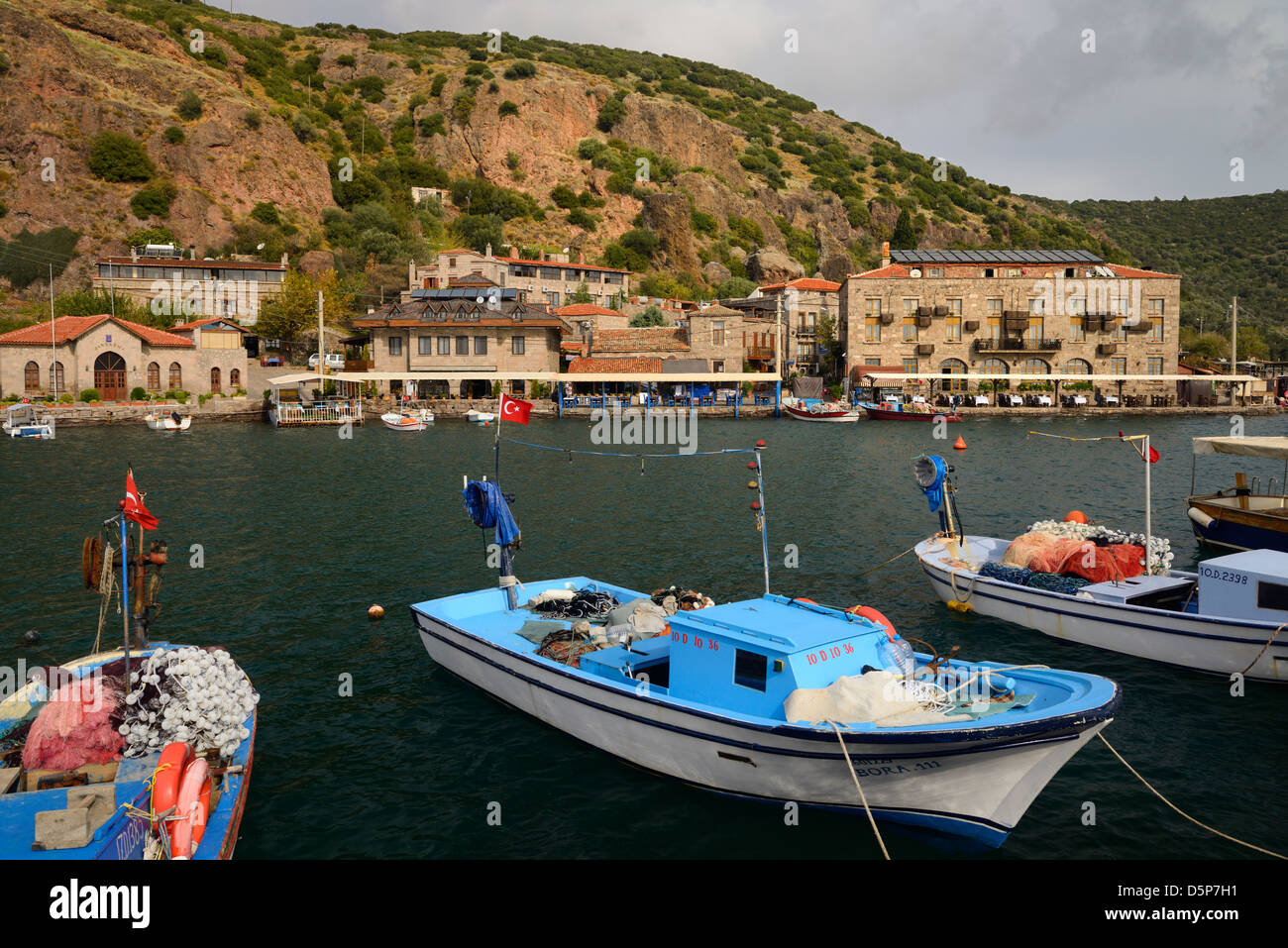 Cliffside village frazione di assos iskele o behram Turchia con barche di alberghi e ristoranti Foto Stock