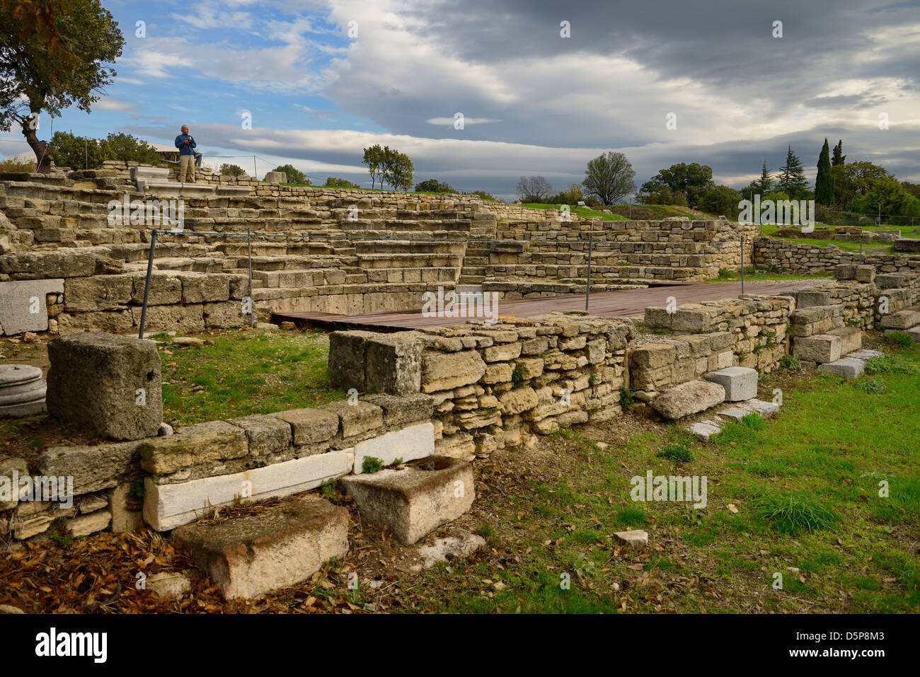 Uomo in piedi sulla parte superiore dell'antico Teatro Odeon sito archeologico di Troia Hisarlik in Turchia Foto Stock