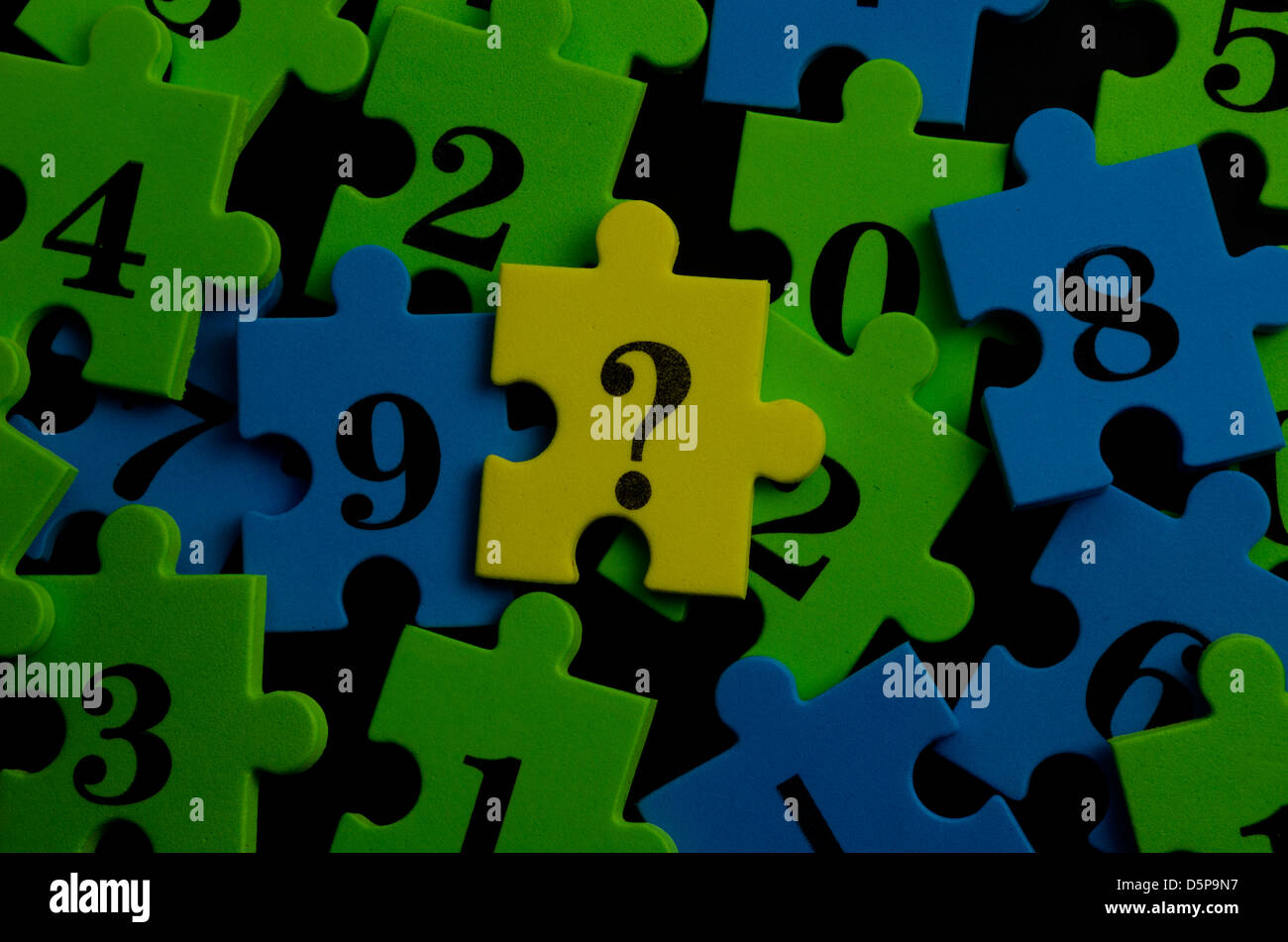 Math colorato i pezzi del puzzle di numeri e un punto interrogativo Foto Stock