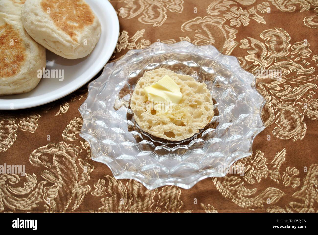 Un servita imburrata muffin inglese Foto Stock