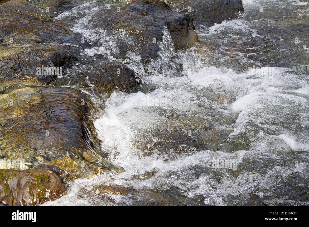 Una piccola cascata nel flusso rocciose Foto Stock