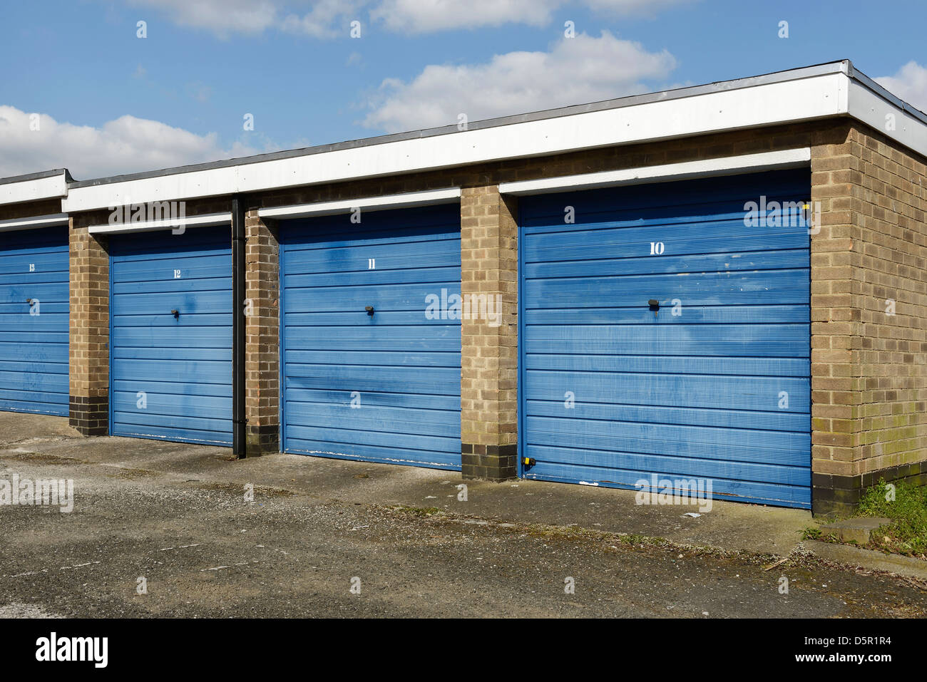 Fila di garage singolo con porte blu Foto Stock