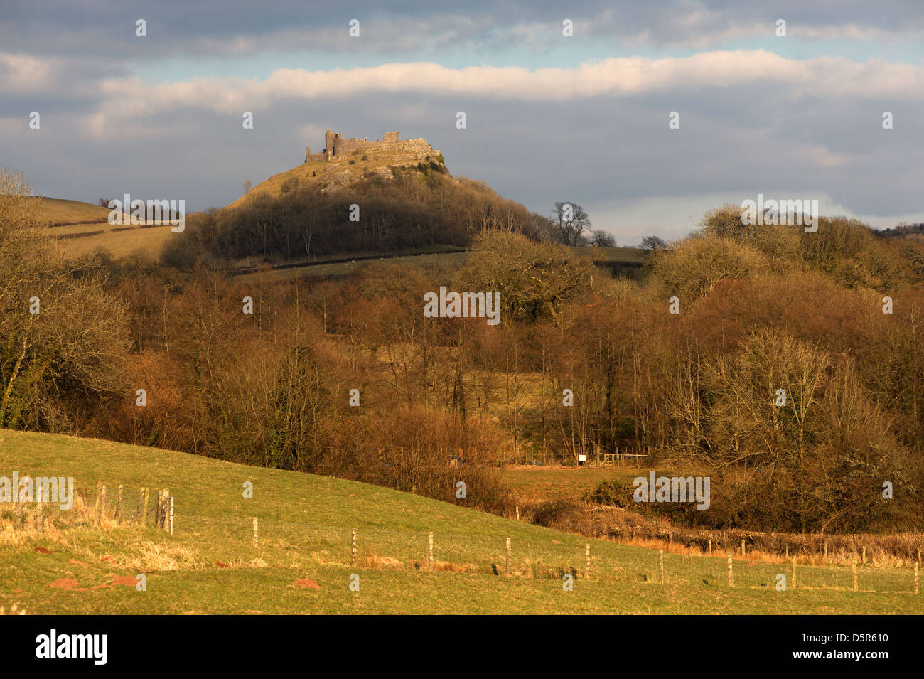 Hill Top castello Carreg Cennen in Galles spotlit da un vbreakin delle nuvole è circondato da valle boscosa e comandi impressionanti viste Foto Stock