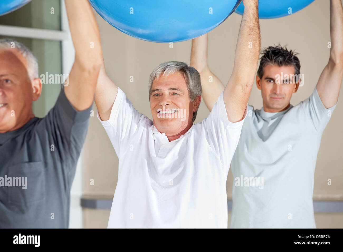 I cittadini anziani facendo esercizi per la schiena con palestra palle nel centro fitness Foto Stock