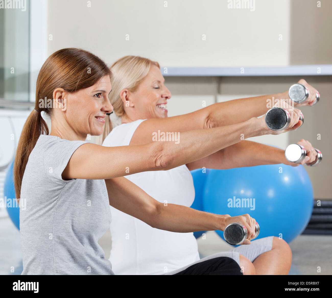 Due senior delle donne che esercitano con manubri in centro fitness Foto Stock