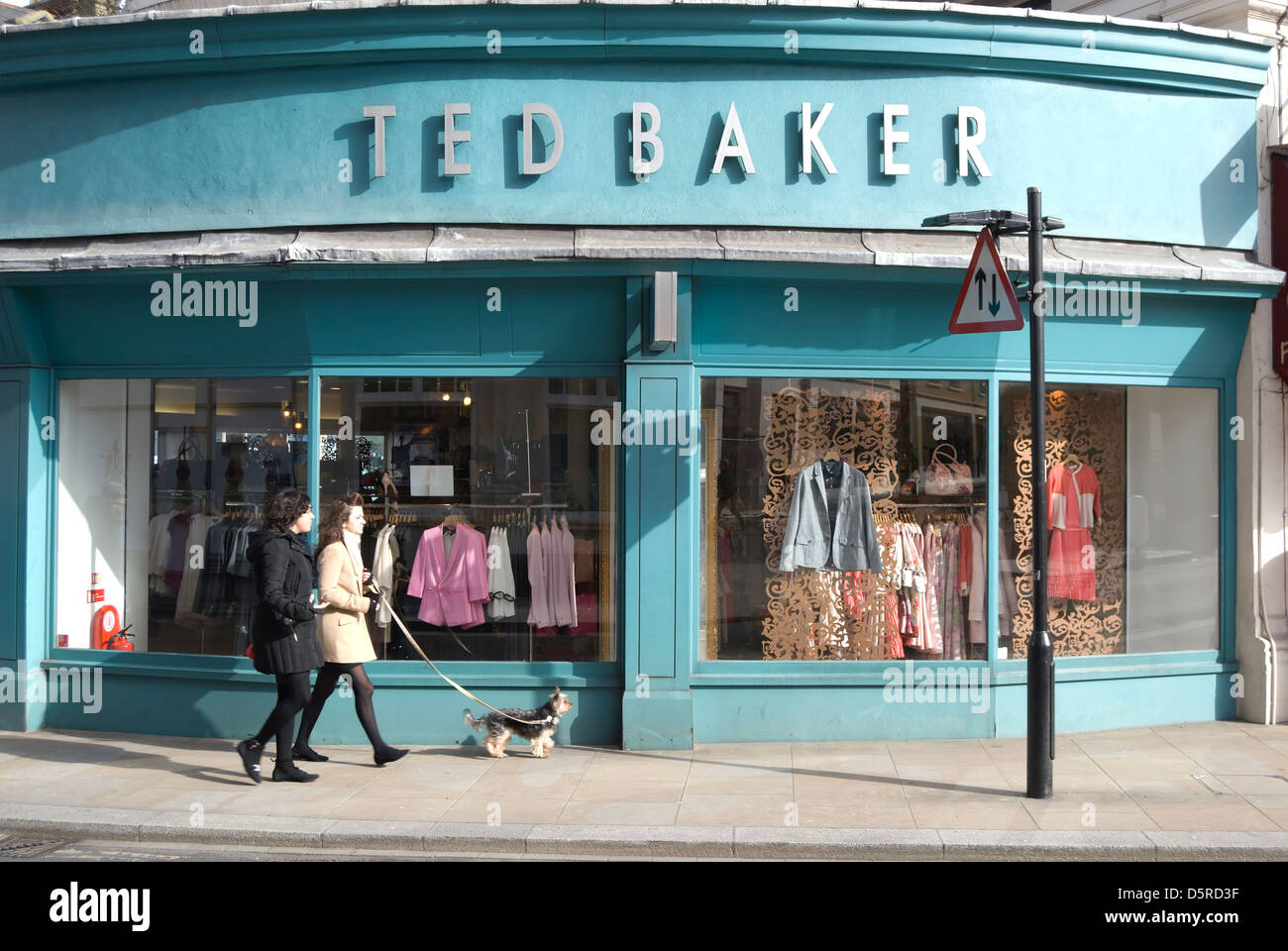 Due donne con un cane passano un ramo del rivenditore di abbigliamento Ted Baker, Richmond upon Thames, Surrey, Inghilterra Foto Stock