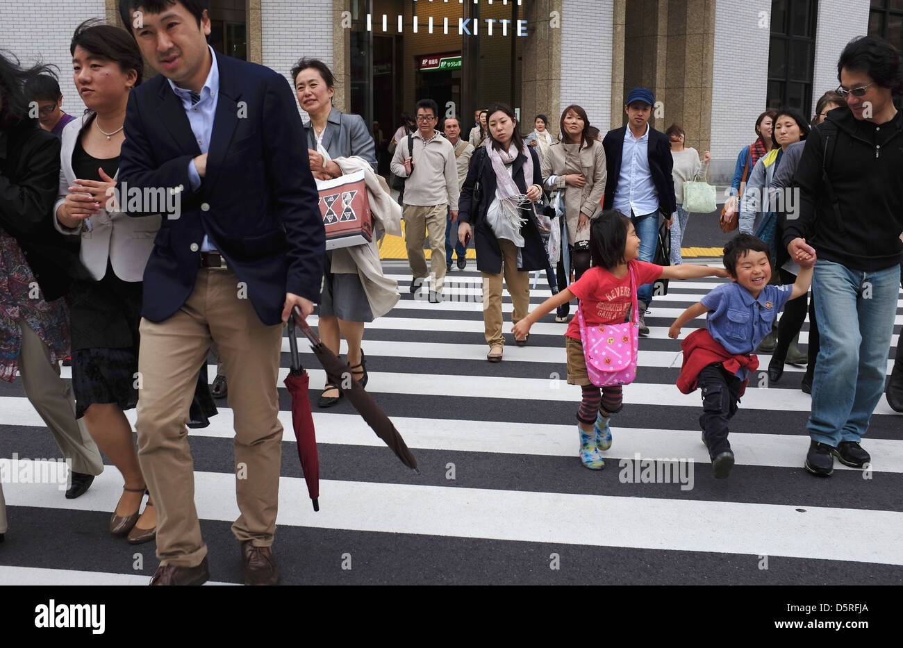 La gente che camminava su un attraversamento pedonale di fronte Kitte Marunouchi. Foto Stock