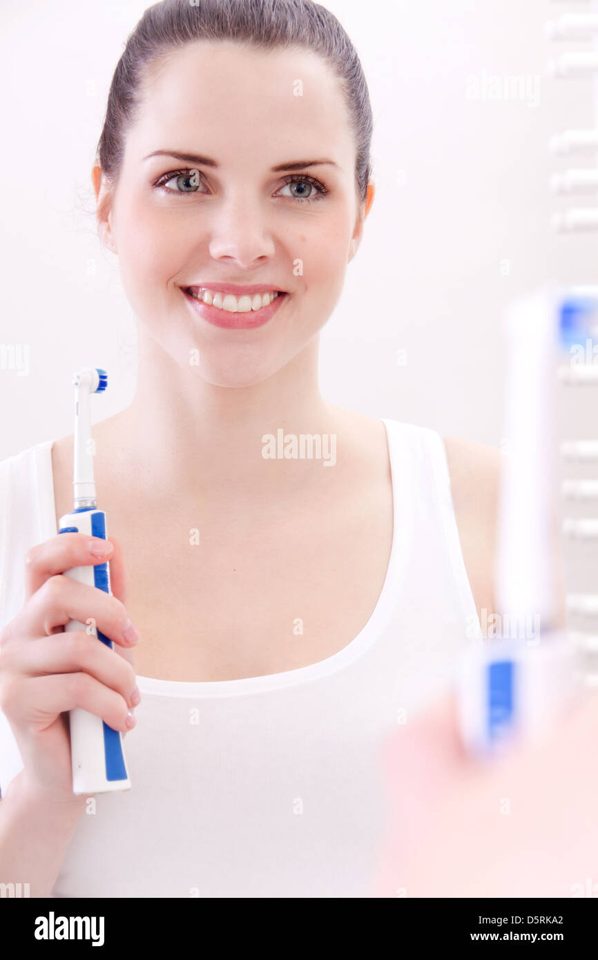 Attraente donna sorridente con spazzolino da denti Specchio bagno ritratto Foto Stock