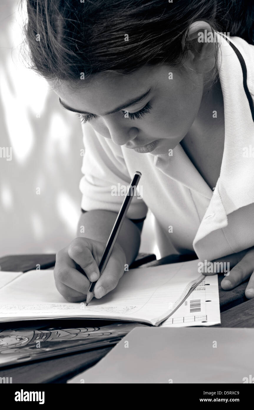 Junior schoolgirl le catture con i suoi studi nella scuola di sole parco giochi campus ( RGB tonica B+W) Foto Stock