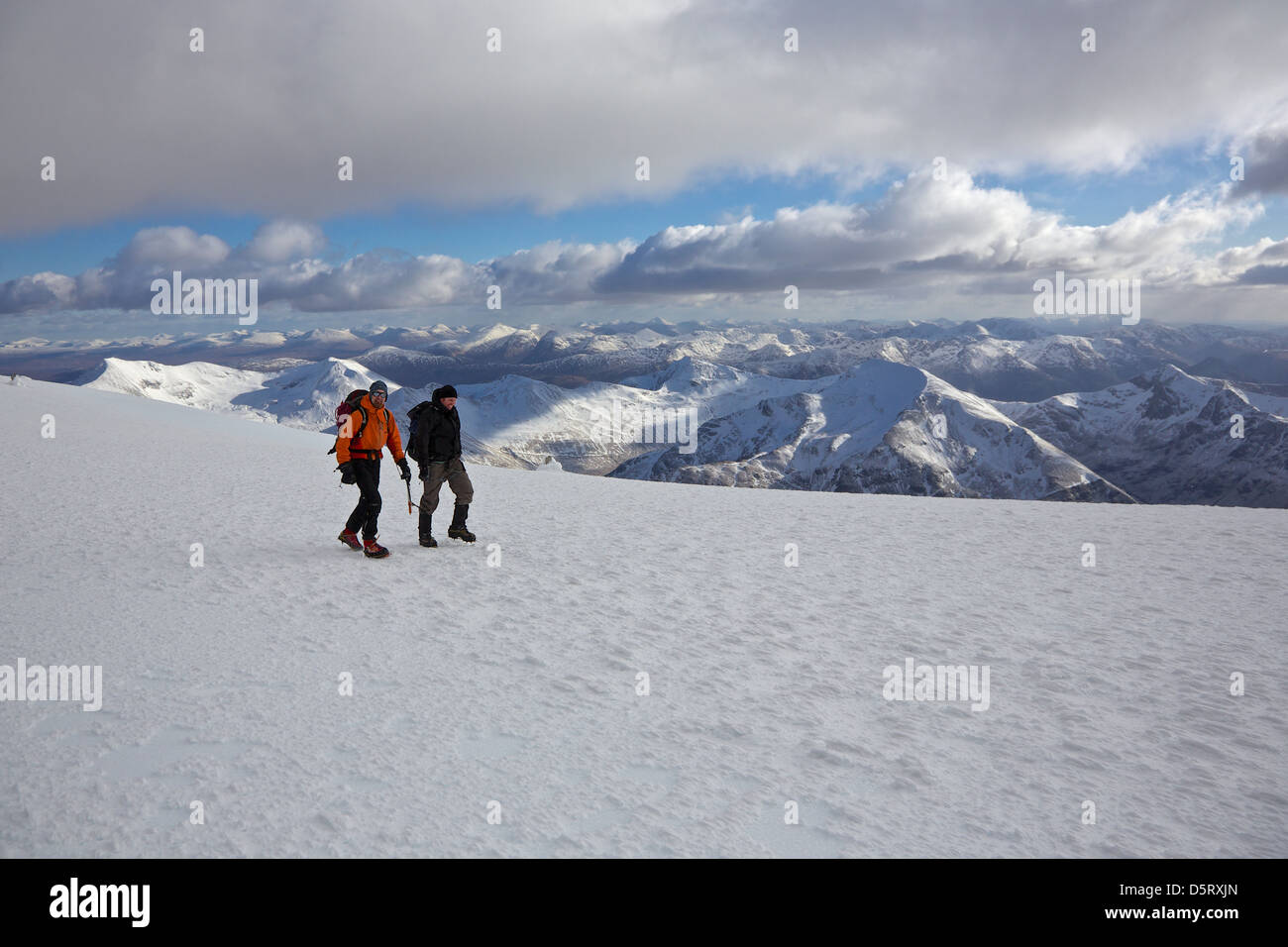 Due alpinisti iniziano la discesa dalla coperta di neve vertice del Ben Nevis in buone condizioni Foto Stock