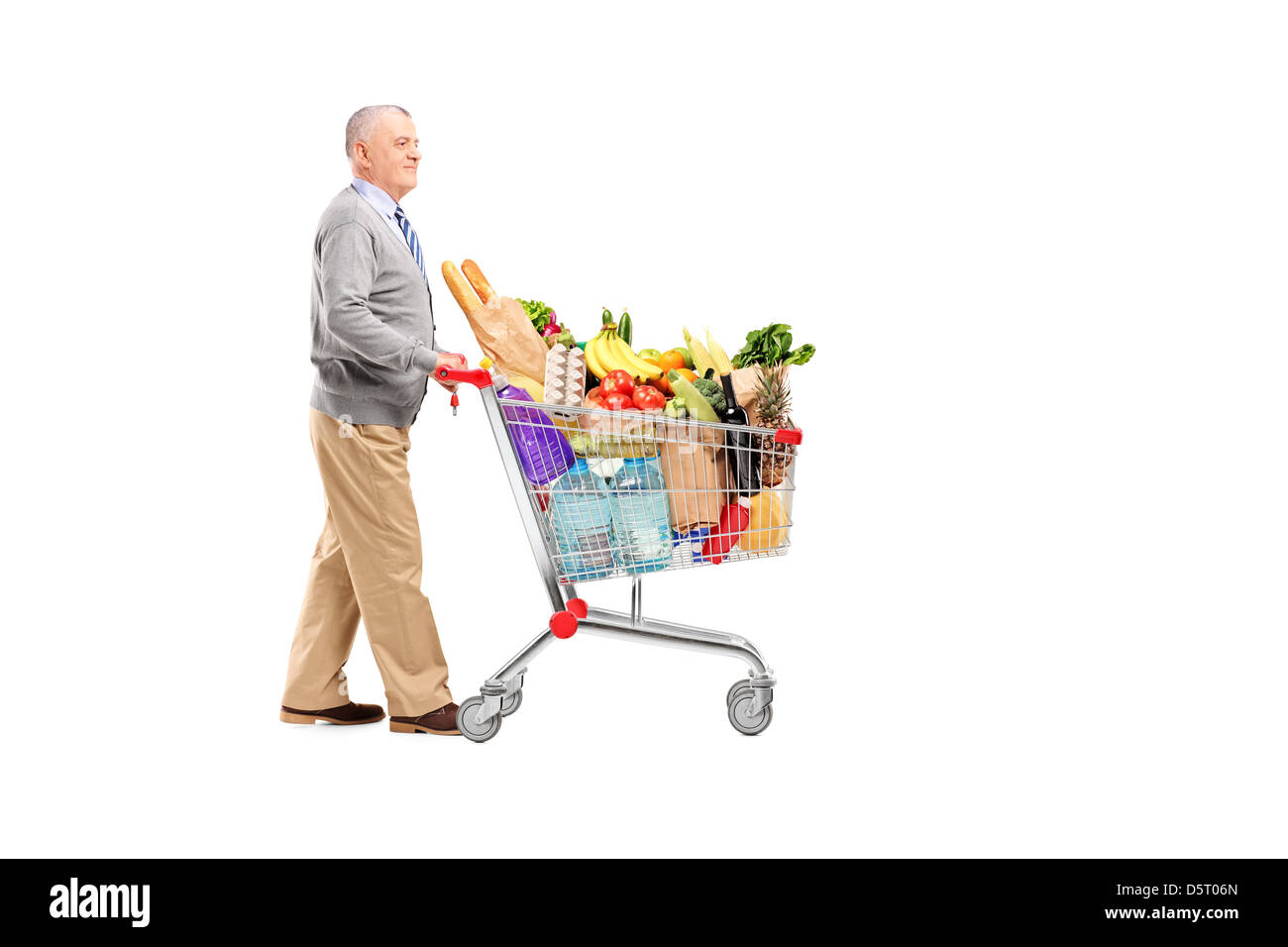 A piena lunghezza Ritratto di un gentiluomo spingendo un carrello pieno di negozi di generi alimentari isolati su sfondo bianco Foto Stock