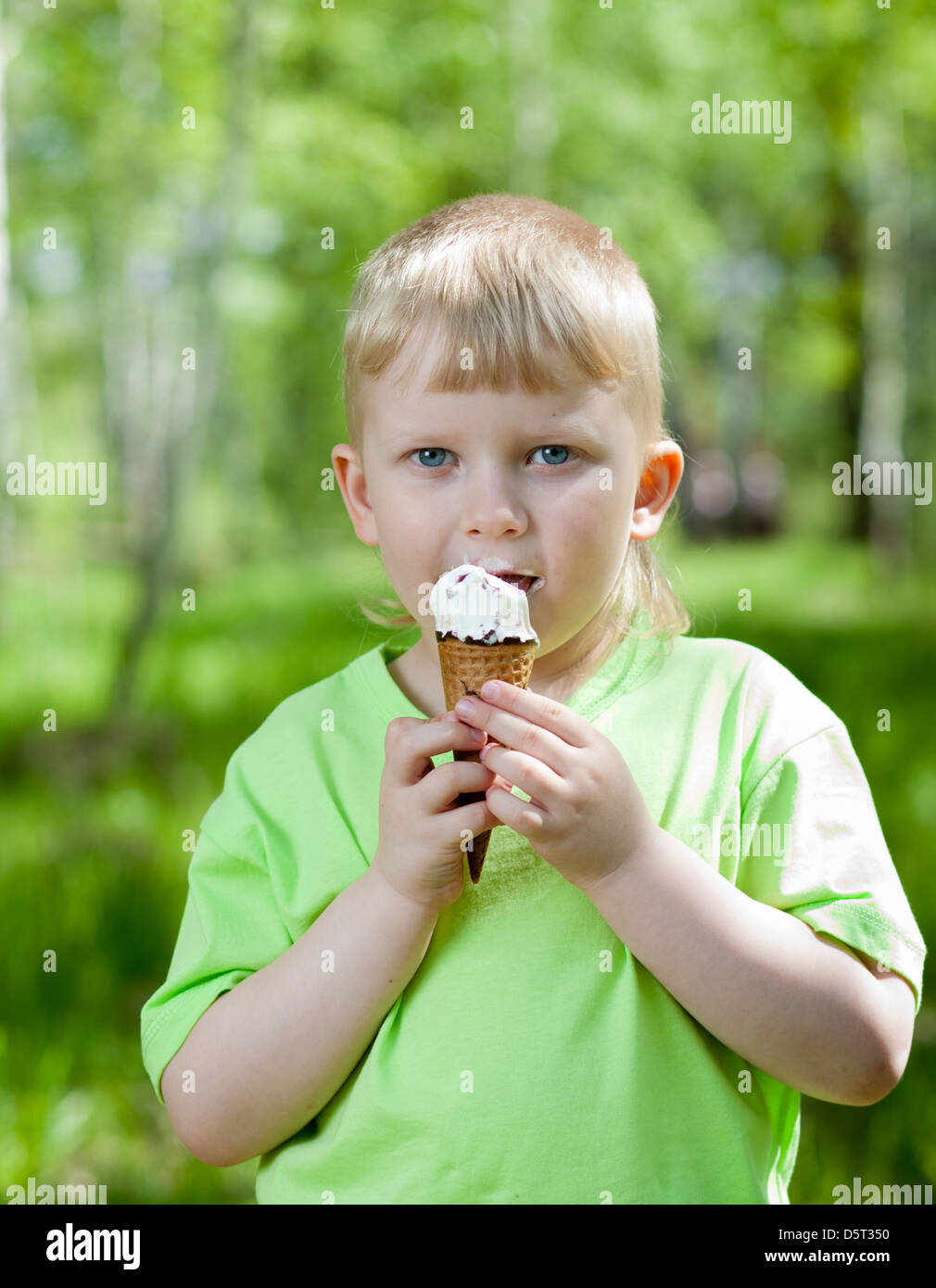 Ragazzo di mangiare un gustoso gelato all'aperto Foto Stock