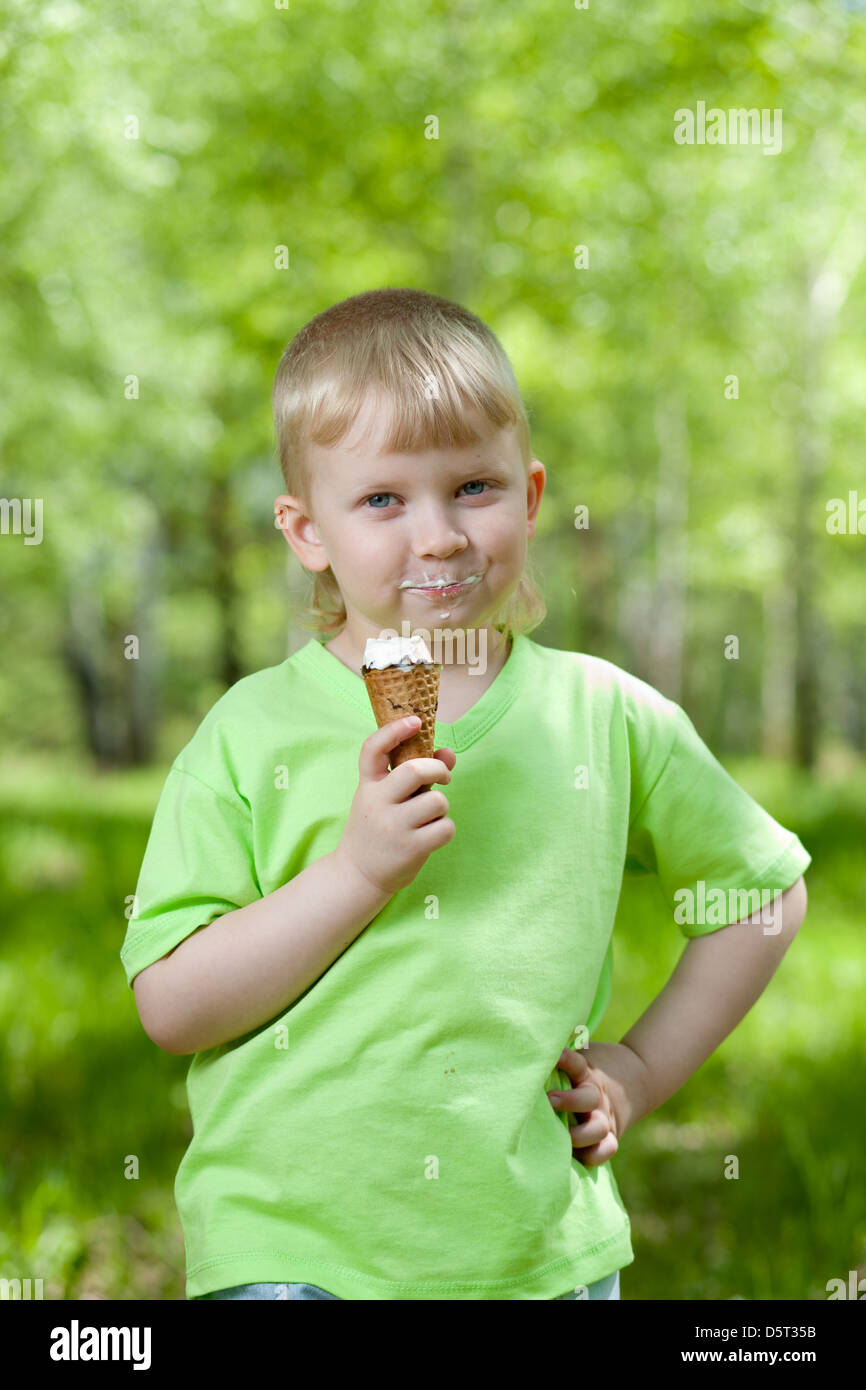 Capretto felice di mangiare un gustoso gelato all'aperto Foto Stock