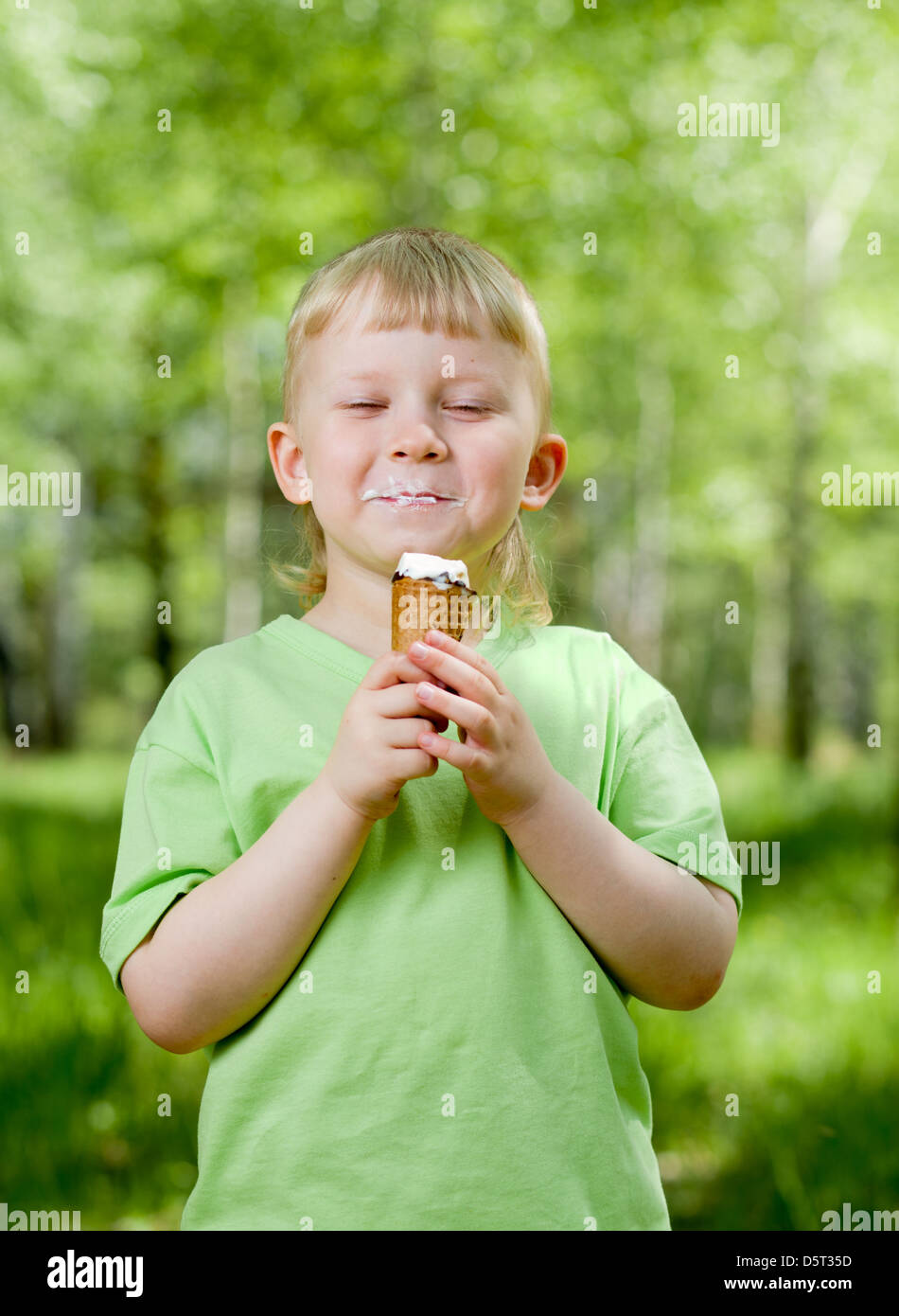 Un giovane bambino mangiare un gelato per esterno Foto Stock
