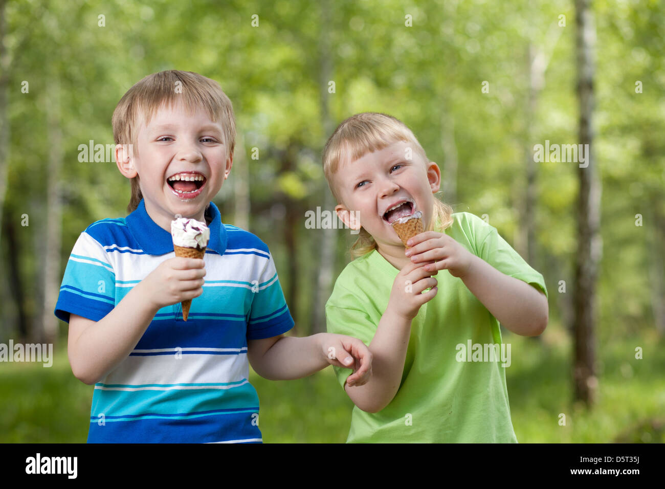 I bambini a mangiare un gustoso gelato all'aperto Foto Stock
