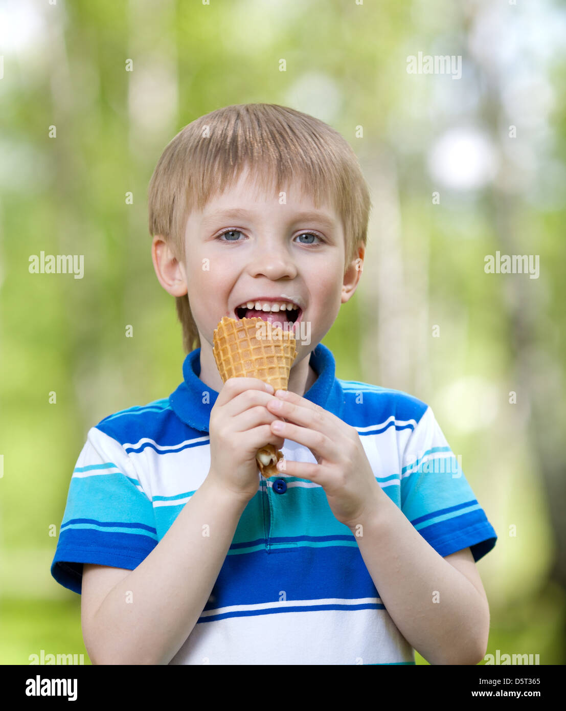 Ragazzo bambino mangiare un gustoso gelato all'aperto Foto Stock