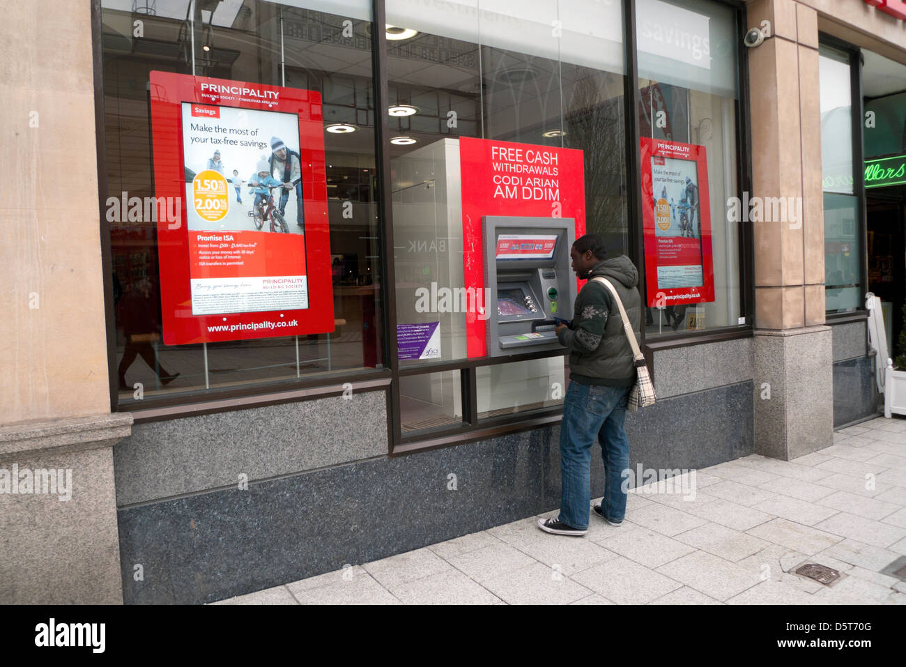 Persona che utilizza il Principato Building Society banca bancomat su Queen Street nella città di Cardiff Wales UK Foto Stock