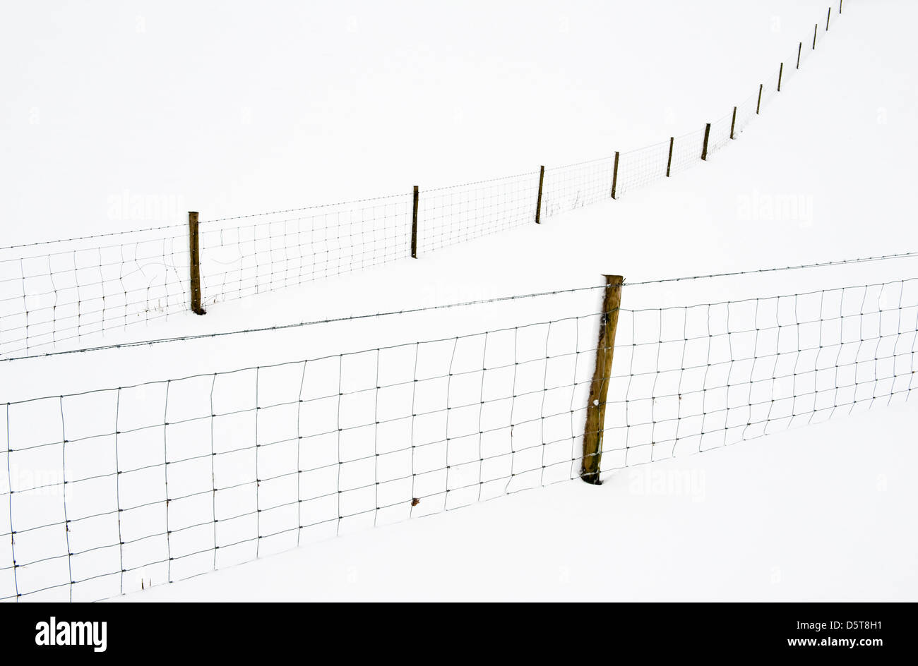 Campi innevati e recinzioni nel Galles centrale fanno modelli astratti Durante la primavera fredda del Regno Unito del 2013 Foto Stock