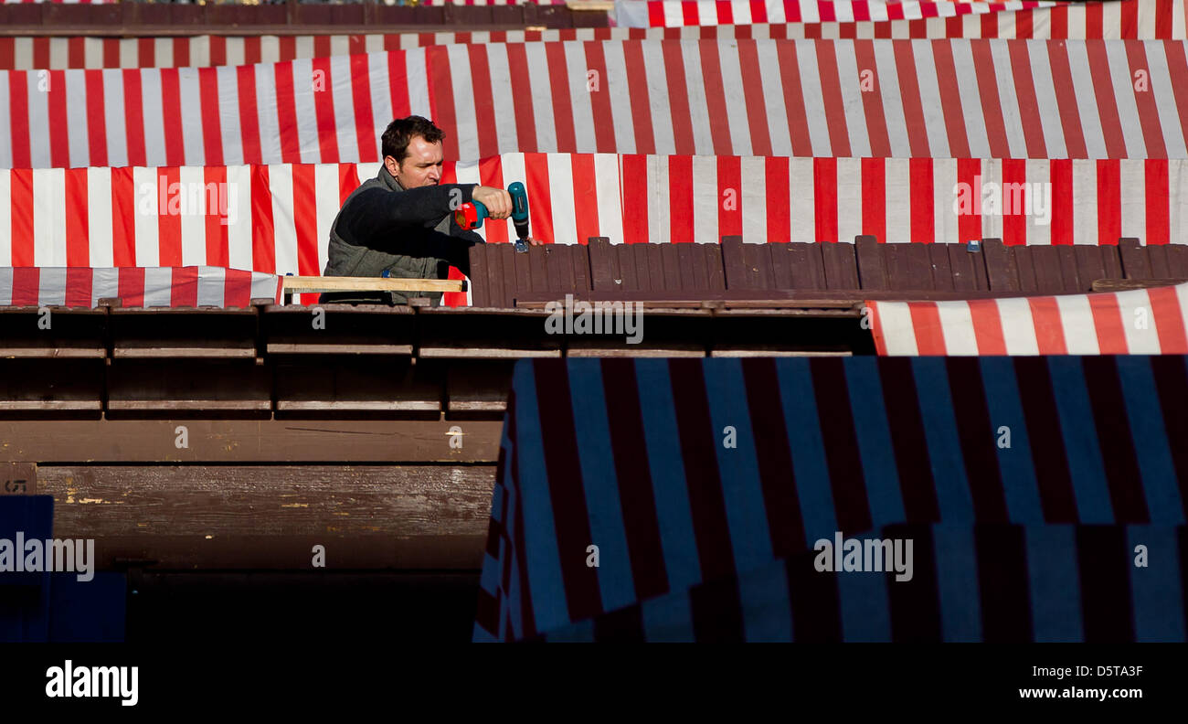 Un uomo installa un coperchio protettivo in corrispondenza di una cabina del mercato Christkindles in Nuremberg, Germania, 19 novembre 2012. Il mercato si apre in 30 novembre 2012. Foto: Daniel Karmann Foto Stock