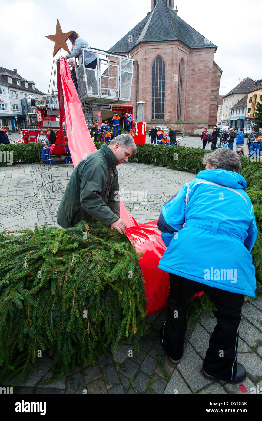 Mario Facco (L), la testa del turista Zweibrueck Commissione attaccare nastri rossi per una grande corona di Avvento con aiutanti su Alexanderplatz in sede di Zweibruecken, Germania, 24 novembre 2012. La corona è presumibilmente il più grande free standing corona di Avvento nel mondo con un diametro di 9 metri. Foto: OLIVER DIETZE Foto Stock