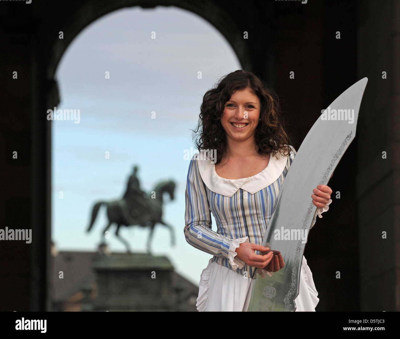 Lo Stollen Maiden Cynthia Brozek mostra un coltello gigante di fronte alla statua equestre di re Giovanni a Dresda, Germania, 26 novembre 2012. Il gigante coltello sarà utilizzato per il taglio a tre tonnellate Stollen sul 08 dicembre 2012. Foto: MATTHIAS HIEKEL Foto Stock