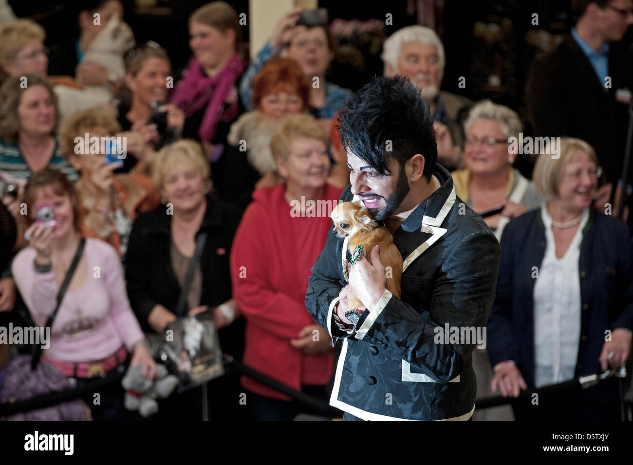 Fashion designer Harald Gloeoeckler detiene un piccolo cane nelle sue braccia in corrispondenza di un ramo del pet shop catena 'Futterhaus' in Berlin-Britz, Germania, 27 settembre 2012. Il designer ha presentato la sua prima collezione per cani 'Gloeoeckler Dog Couture Karlie dall'. Foto: Robert Schlesinger Foto Stock