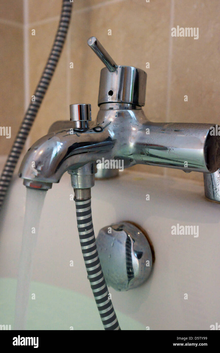 Bagno ad acqua di rubinetto flusso tubo cromato H2O piastrelle Foto Stock