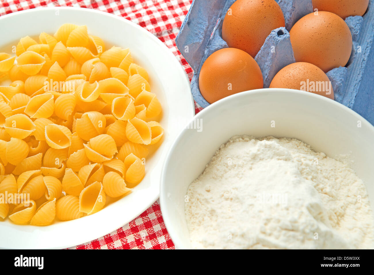 La farina con le uova e la pasta sul tavolo da cucina, crudo ingredienti alimentari. Foto Stock
