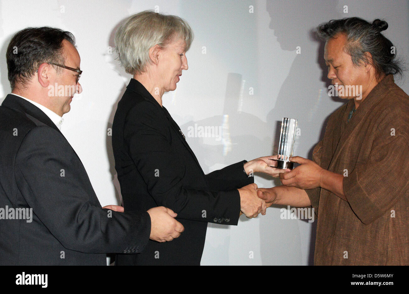 Direttore della Hamburg Film Festival, Albert Wiederspiel (L-R) e Amburgo il senatore per la cultura Barbara Kisseler presente il Douglas Sirk premio al sud regista coreano Kim Ki-duk ad Amburgo, Germania, 04 ottobre 2012. Kim Ki-duk ha ricevuto il premio per il suo film "Pieta'. Foto: Georg Wendt Foto Stock
